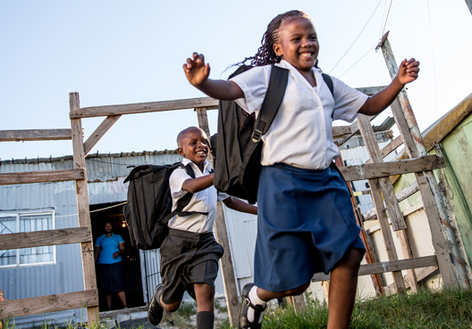 Grade 4 learners leaving home to go to school Grade 4 learners leaving their home with smiles on their faces, wearing their school uniforms and backpacks